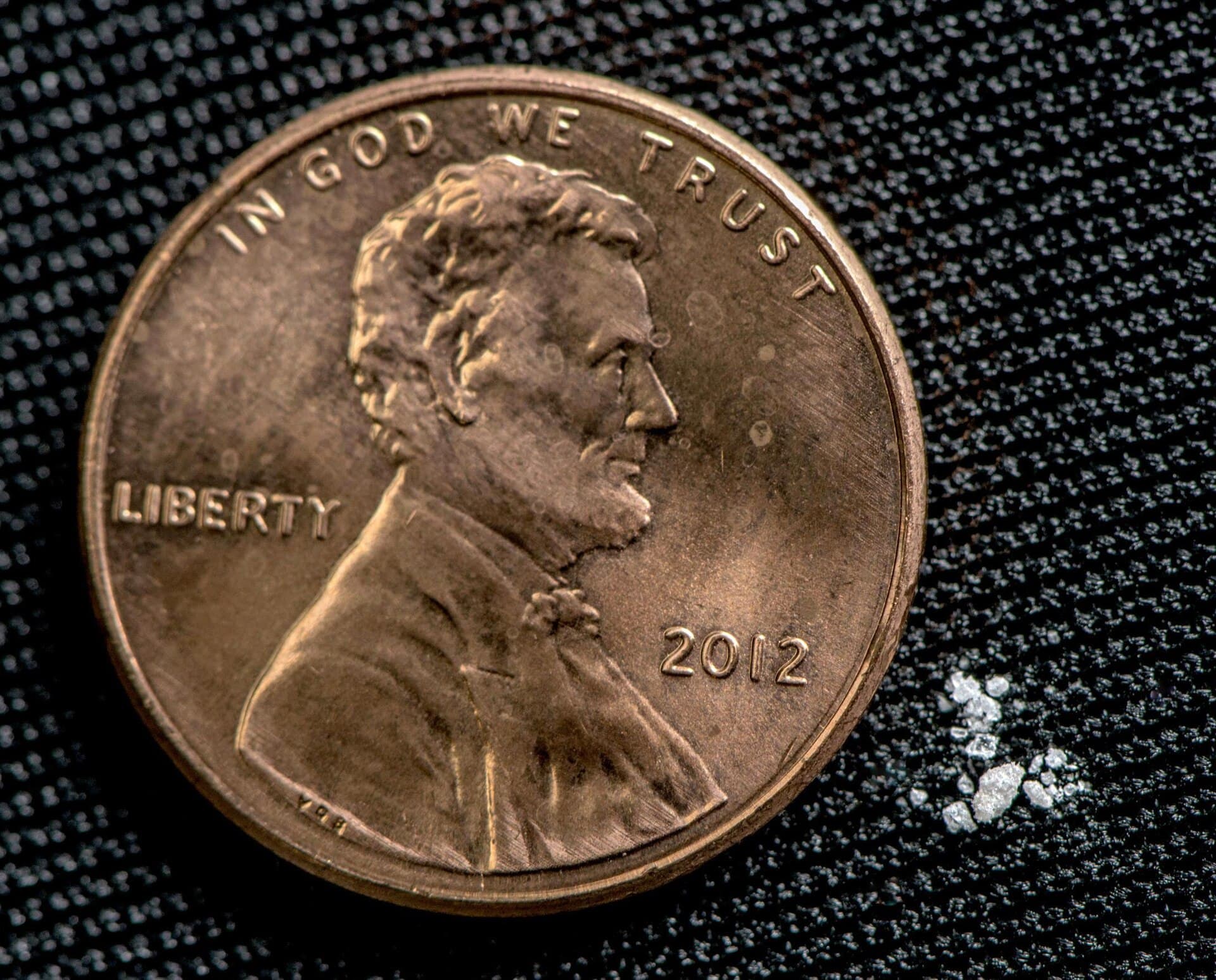 A small pile of fentanyl powder, about 2 milligrams, beside a penny, in a DEA photo illustration