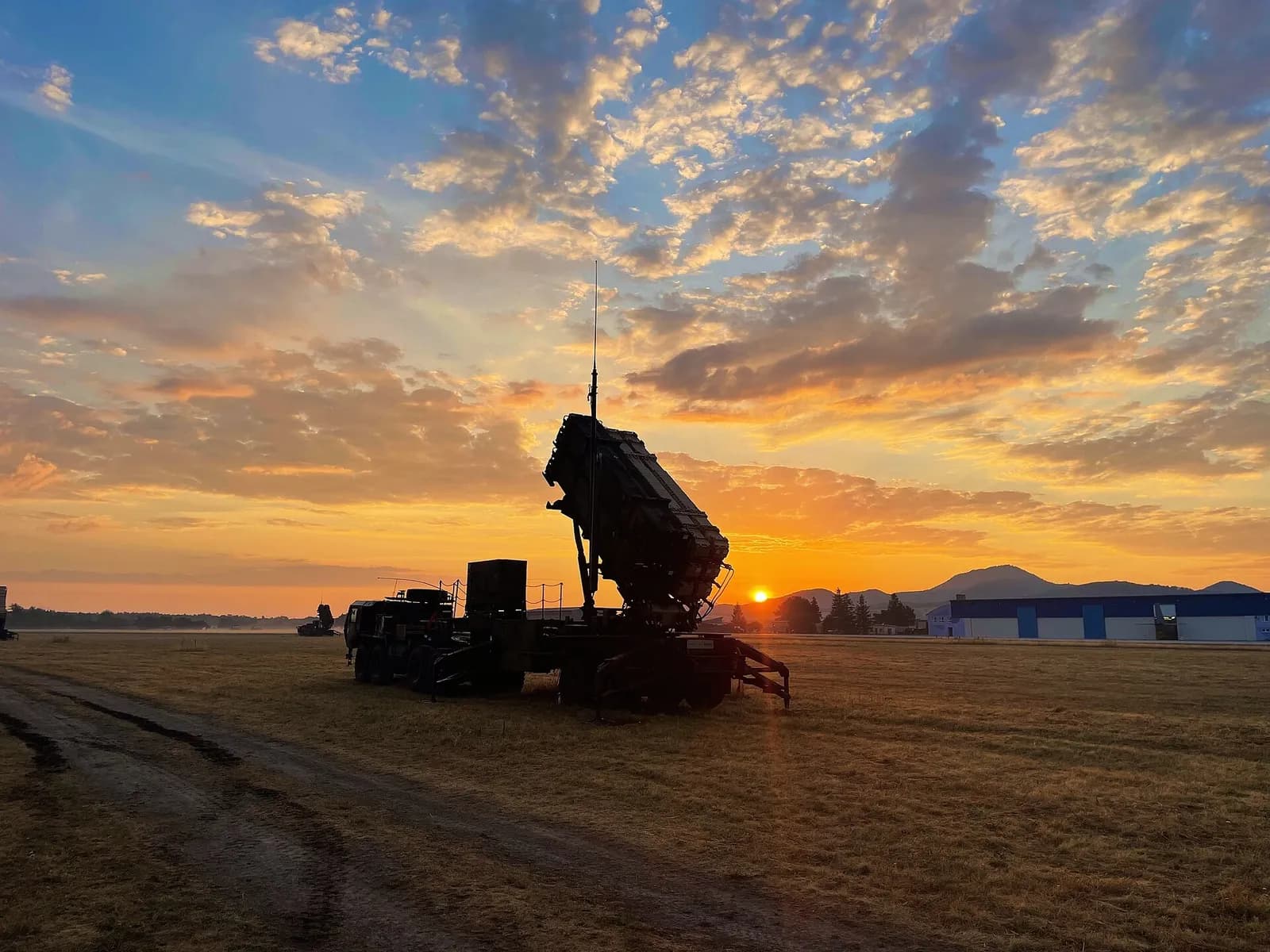A Patriot air-defense missile launcher silhouetted against a sunrise during a deployment in Slovakia